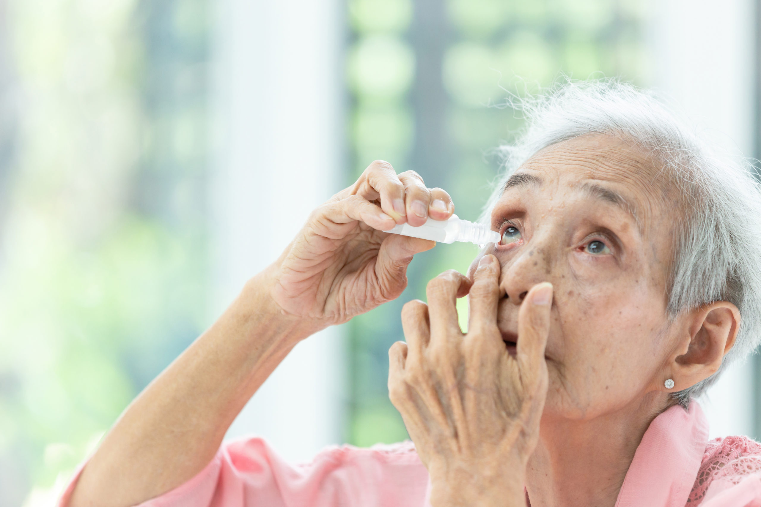 asian-senior-woman-putting-eye-dropcloseup-view-of-elderly-person-using-bottle-of-eyedrops-in-her-eyessick-old-woman-suffering-from-irritated-eyeoptical-symptomshealth-concept