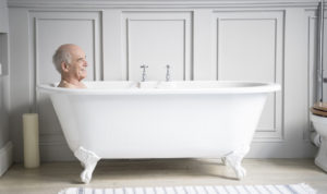 senior-man-relaxing-in-traditional-white-bath-smiling