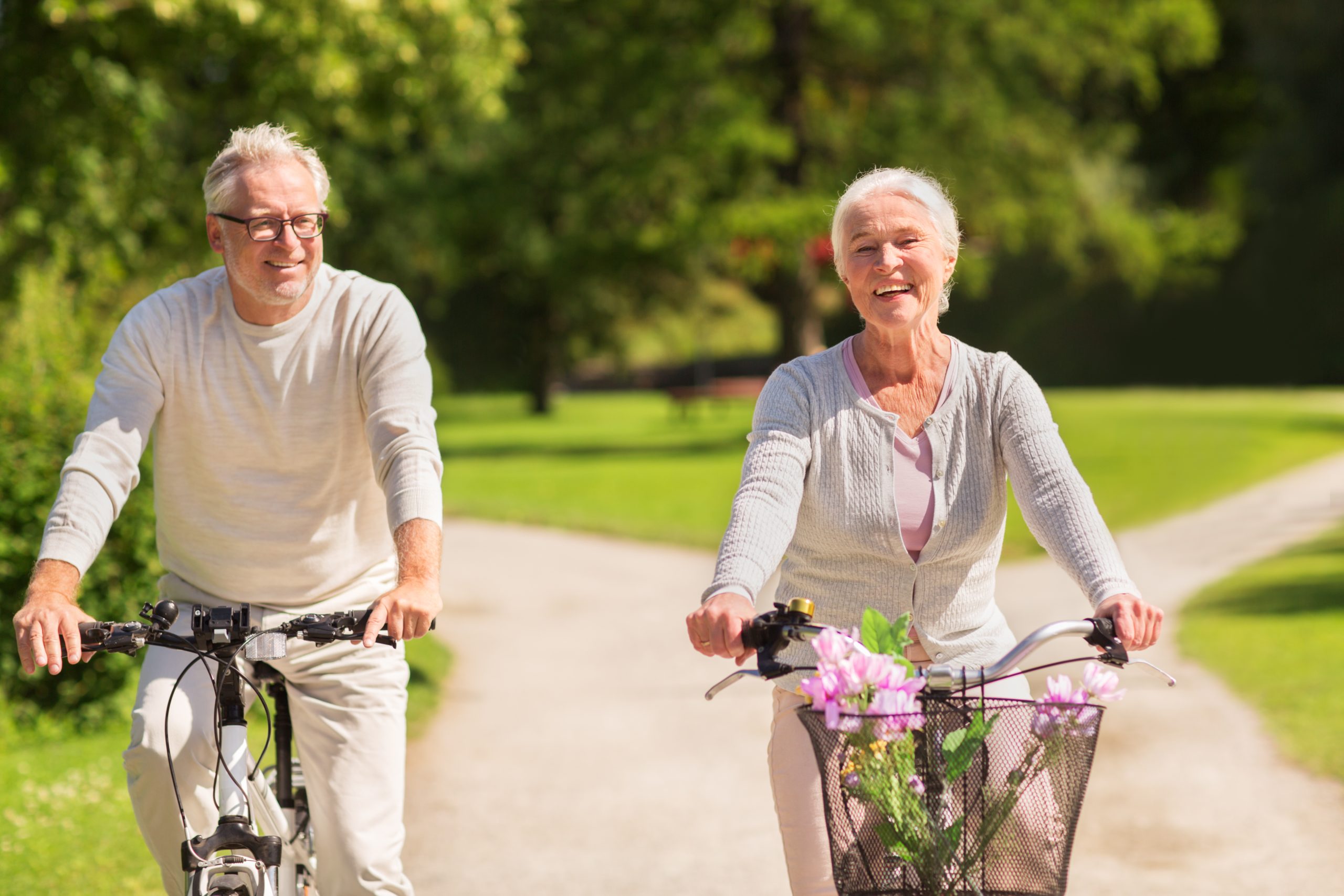 happy-senior-couple-riding-bicycles-at-summer-park