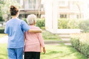 nurse-caregiver-support-walking-with-elderly-woman-outdoor